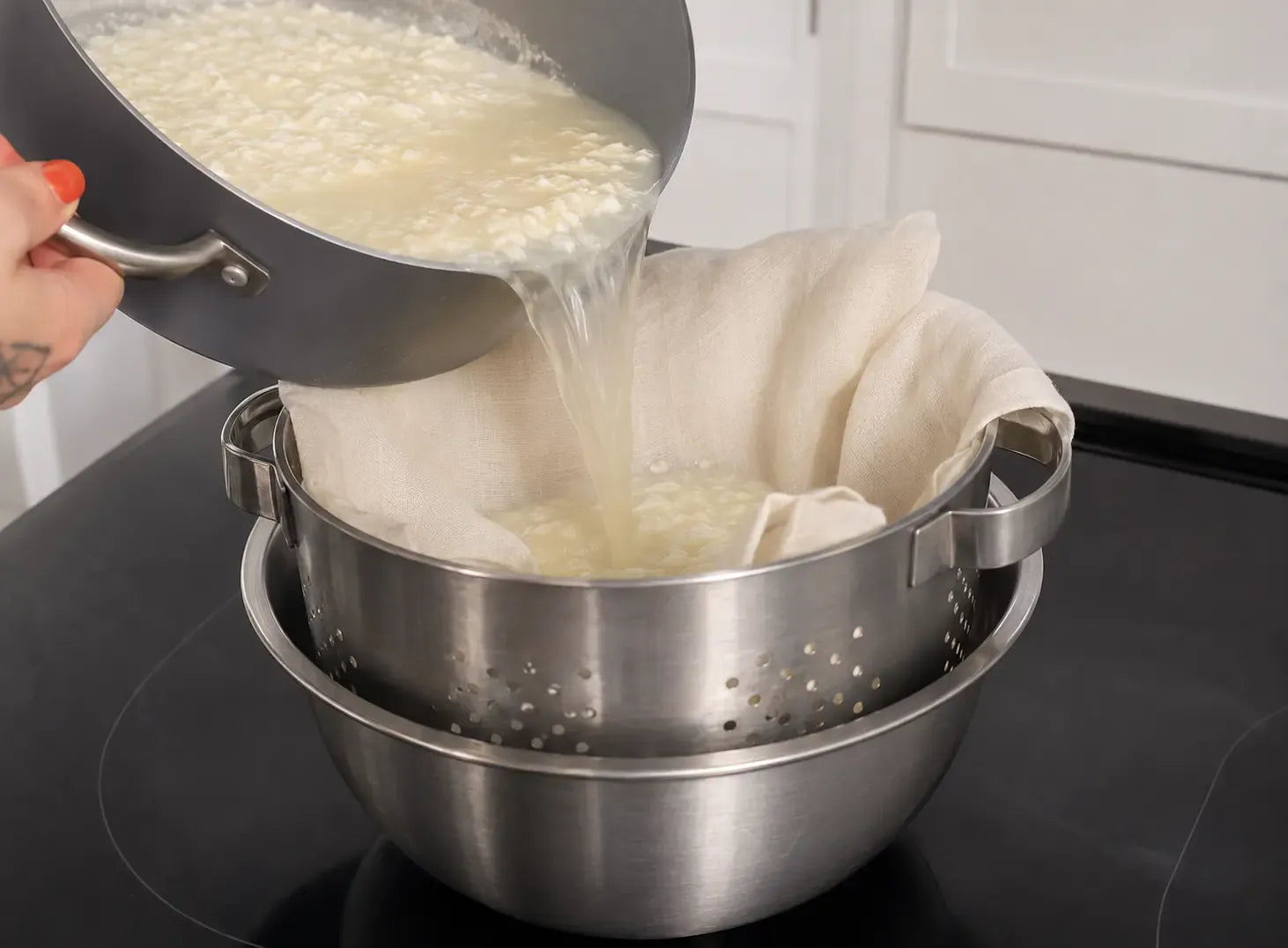 Curds poured into a muslin-lined colander