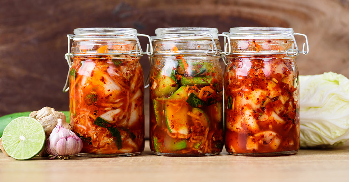 pickled vegetables and sauerkraut in jars on a table